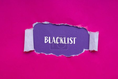 Mot de la liste noire écrit sur papier rose déchiré avec fond violet. Symbole conceptuel de la liste noire. Espace de copie.