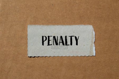 Penalty word written on ripped paper piece with brown background. Conceptual penalty symbol. Copy space.