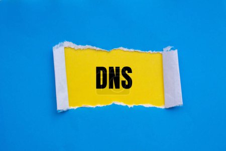 Mot DNS écrit sur papier bleu déchiré avec fond jaune. Symbole DNS conceptuel. Espace de copie.