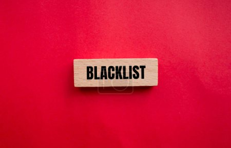 Mot de la liste noire écrit sur un bloc de bois avec fond rouge. Symbole conceptuel de la liste noire. Espace de copie.