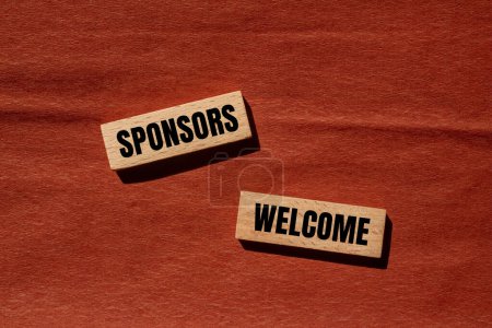 Sponsors welcome words written on wooden blocks with brown background. Conceptual business symbol. Copy space.