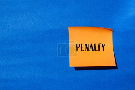 Penalty word written on orange paper sticker with blue background. Conceptual penalty symbol. Copy space.