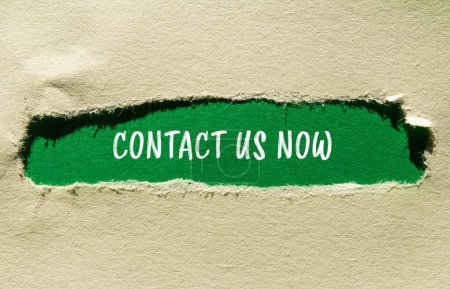 Contact us now words written on ripped paper with green background. Conceptual contact us now symbol. Copy space.