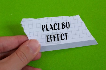 Mots à effet placebo écrits sur du papier déchiré avec fond vert. Symbole conceptuel de l'effet placebo. Espace de copie.