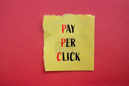 Payez par clic les mots écrits sur papier jaune déchiré avec fond rouge. Rémunération conceptuelle par clic symbole PPC. Espace de copie.