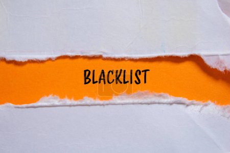 Mot de la liste noire écrit sur du papier déchiré avec fond orange. Symbole conceptuel de la liste noire. Espace de copie.