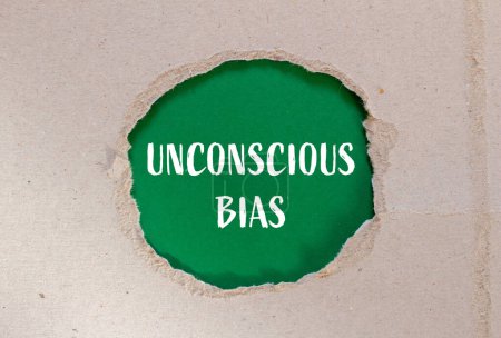 Unconscious bias words written on ripped paper with green background. Conceptual unconscious bias symbol. Copy space.