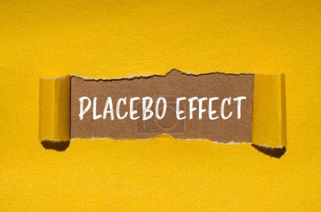 Mots à effet placebo écrits sur papier jaune déchiré avec fond brun. Symbole conceptuel de l'effet placebo. Espace de copie.