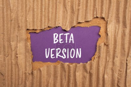Beta version words written on ripped cardboard paper with purple background. Conceptual beta version symbol. Copy space.