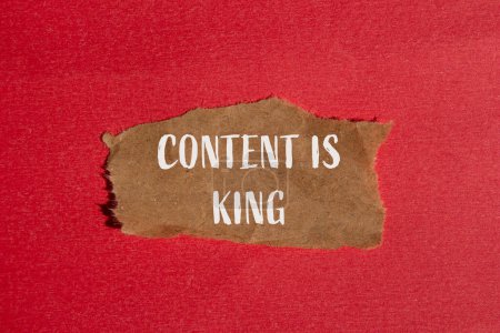 Contenu est roi mots écrits sur morceau de papier brun déchiré avec fond rouge. Le contenu conceptuel est le symbole du roi. Espace de copie.