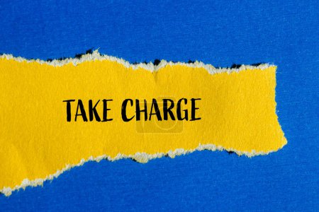 Take charge words written on ripped yellow paper with blue background. Conceptual take charge symbol. Copy space.
