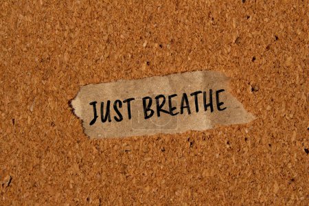 Atmen Sie einfach Worte, die auf ein zerrissenes Papierstück mit braunem Hintergrund geschrieben sind. Konzeptionelle Atmung einfach Symbol. Kopierraum.