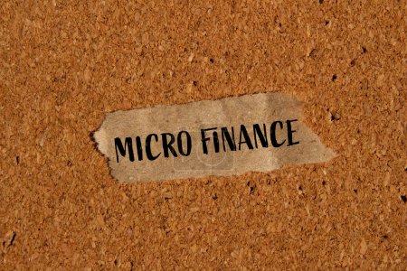 Palabras de micro finanzas escritas en papel rasgado con fondo marrón. Símbolo conceptual de microfinanzas. Copiar espacio.