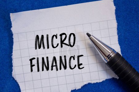 Palabras de micro finanzas escritas en papel blanco rasgado con fondo azul. Símbolo conceptual del negocio de microfinanzas. Copiar espacio.