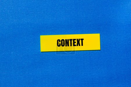 Foto de Palabra contextual escrita en papel amarillo con fondo azul. Símbolo de contexto conceptual. Copiar espacio. - Imagen libre de derechos