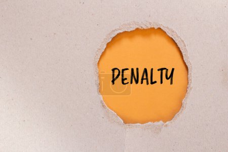 Penalty word written on ripped paper with orange background. Conceptual penalty symbol. Copy space.