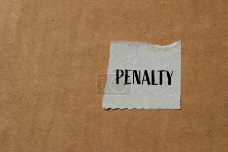 Penalty word written on ripped paper piece with brown background. Conceptual penalty symbol. Copy space.