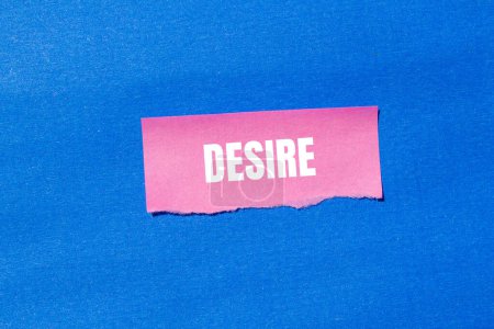 Desire word written on ripped pink paper with blue background