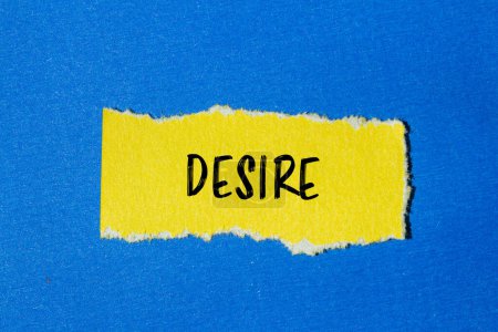 Desire word written on ripped yellow paper with blue background