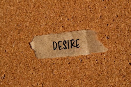 Desire word written on ripped paper piece with brown background. Conceptual desire symbol. Copy space.