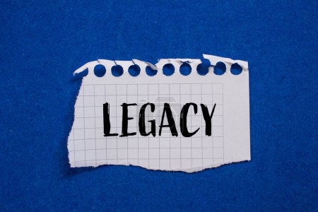 Legacy word written on ripped white paper with blue background. Conceptual legacy symbol. Copy space.