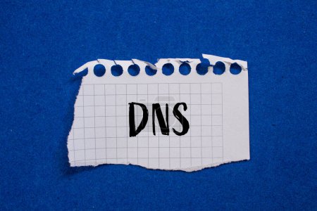 Mot DNS écrit sur papier blanc déchiré avec fond bleu. Symbole DNS conceptuel. Espace de copie.