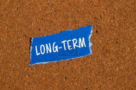 Photo for Long term words written on ripped blue paper piece with brown background. Conceptual long term symbol. Copy space. - Royalty Free Image