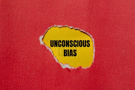 Unconscious bias words written on ripped red paper with yellow background. Conceptual unconscious bias symbol. Copy space.