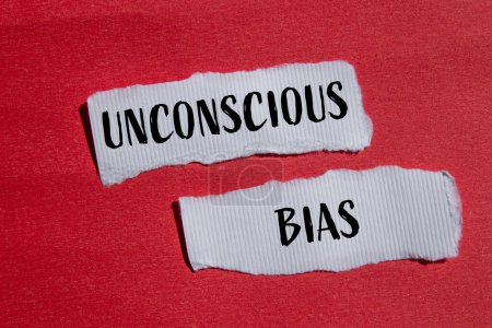 Unconscious bias words written on ripped white paper pieces with red background. Conceptual unconscious bias symbol. Copy space.