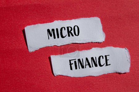 Palabras de micro finanzas escritas en pedazos de papel blanco rasgados con fondo rojo. Símbolo conceptual de microfinanzas empresariales. Copiar espacio.