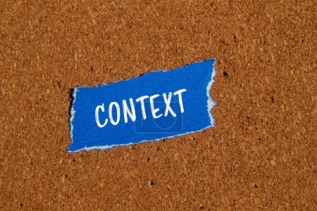 Context word written on ripped blue paper piece with brown background. Conceptual context symbol. Copy space.