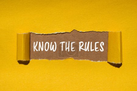 Connaître les règles mots écrits sur papier jaune déchiré avec fond brun. Conceptuel connaître le symbole des règles. Espace de copie.
