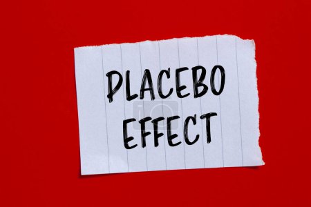 Mots à effet placebo écrits sur du papier déchiré avec fond rouge. Symbole conceptuel de l'effet placebo. Espace de copie.