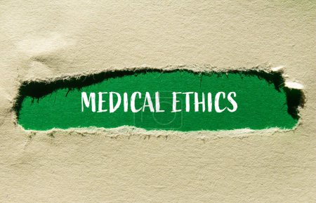 Mots d'éthique médicale écrits sur papier déchiré avec fond vert. Symbole d'éthique médicale conceptuelle. Espace de copie.