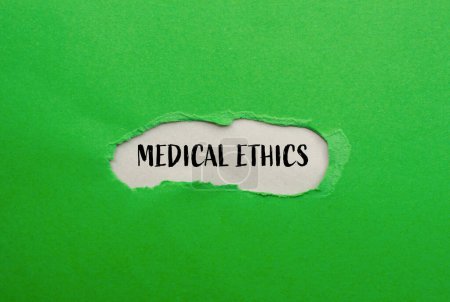 Mots d'éthique médicale écrits sur papier vert déchiré avec fond gris. Symbole d'éthique médicale conceptuelle. Espace de copie.