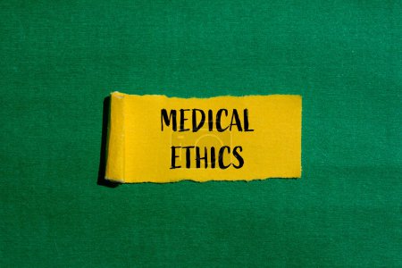 Mots d'éthique médicale écrits sur papier jaune déchiré avec fond vert. Symbole d'éthique médicale conceptuelle. Espace de copie.