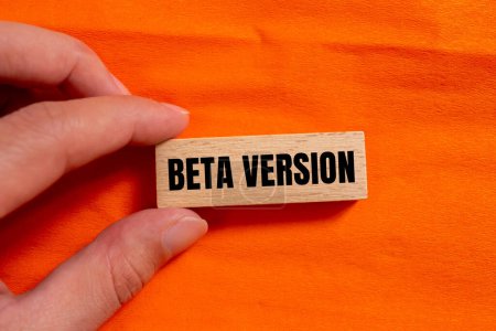 Version bêta mots écrits sur un bloc de bois avec fond orange. Symbole conceptuel de la version bêta. Espace de copie.