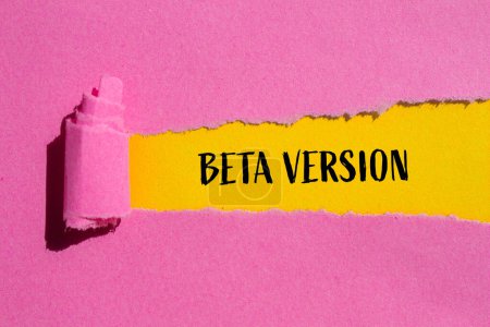 Beta version words written on ripped pink paper with yellow background. Conceptual beta version symbol. Copy space.