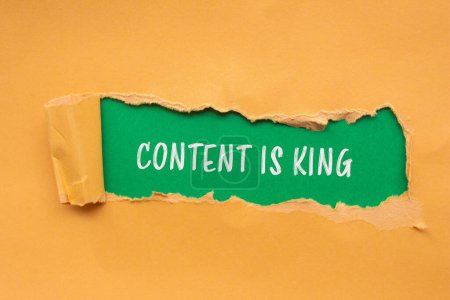Contenu est roi mots écrits sur du papier orange déchiré avec fond vert. Le contenu conceptuel est le symbole du roi. Espace de copie.