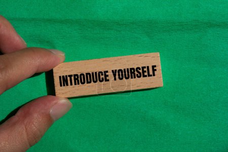 Introduce yourself words written on wooden block with green background. Conceptual introduce yourself symbol. Copy space.