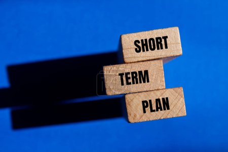 Short term plan words written on wooden blocks with blue background. Conceptual short term plan symbol. Copy space.