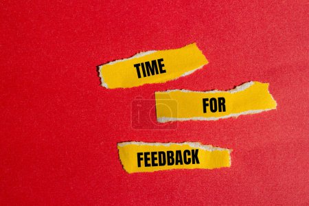 Time for feedback words written on ripped yellow paper pieces with red background. Conceptual time for feedbacksymbol. Copy space.