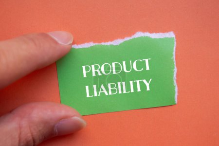 Mots de responsabilité du produit écrits sur papier vert déchiré avec fond orange. Symbole conceptuel de responsabilité du produit. Espace de copie.