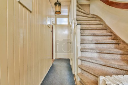 Foto de Pasillo con escalera que conduce al segundo piso y lámpara brillante - Imagen libre de derechos