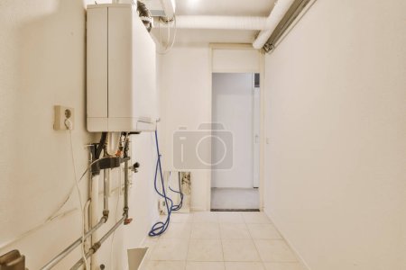 Photo for A very clean white room with some pipes and water heaters on the wall in this photo is taken from inside - Royalty Free Image