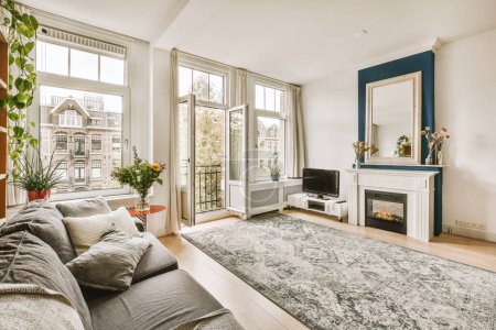Photo for A living room with couches and a fireplace in the corner, surrounded by large windows that look out onto the street - Royalty Free Image
