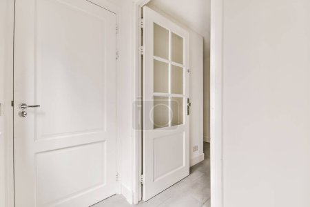 Photo for An empty room with two doors and one door opened to reveal the other rooms in the apartment has white walls - Royalty Free Image