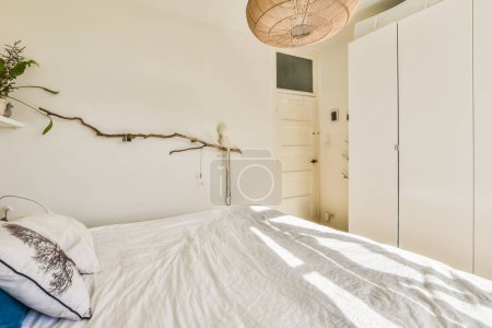 Foto de Un dormitorio con una cama y algunas plantas en los cabeceros colgando de una luz de techo sobre la cama - Imagen libre de derechos