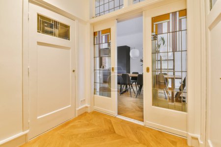 Foto de Una habitación vacía con suelos de madera y puertas de vidrio que conducen al comedor en la habitación es muy luminosa - Imagen libre de derechos