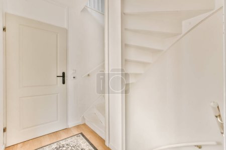 Téléchargez les photos : Une pièce vide avec des murs blancs et du parquet, il y a une porte menant au côté gauche de la pièce - en image libre de droit